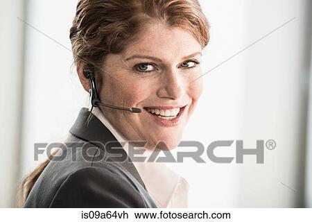 Smiling businesswoman wearing headset View Large Photo Image Stock Image - Smiling businesswoman wearing headset. Fotosearch