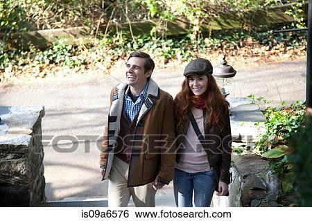 Stock Photograph - Smiling couple climbing front steps. Fotosearch