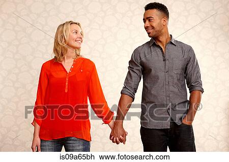 Smiling couple holding hands View Large Photo Image Stock Image - Smiling couple holding hands. Fotosearch