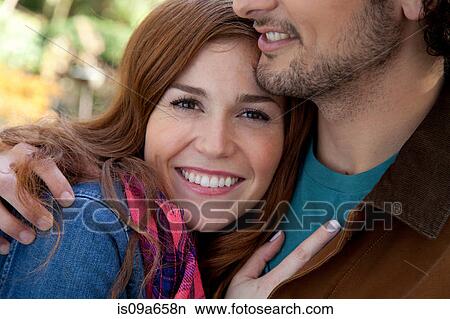Smiling couple hugging outdoors View Large Photo Image Picture - Smiling couple hugging outdoors. Fotosearch