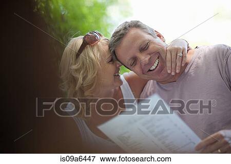 Smiling couple reading menu outdoors View Large Photo Image Stock Photo - Smiling couple reading menu outdoors. Fotosearch