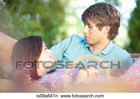 Picture - Smiling couple relaxing in park. Fotosearch