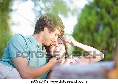Smiling couple relaxing in park View Large Photo Image Stock Image - Smiling couple relaxing in park. Fotosearch