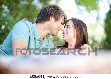 Smiling couple relaxing in park View Large Photo Image Stock Image - Smiling couple relaxing in park. Fotosearch