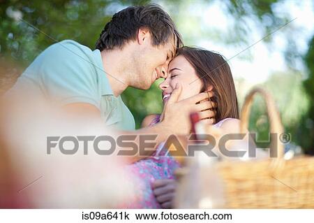 Smiling couple relaxing in park View Large Photo Image Stock Image - Smiling couple relaxing in park. Fotosearch