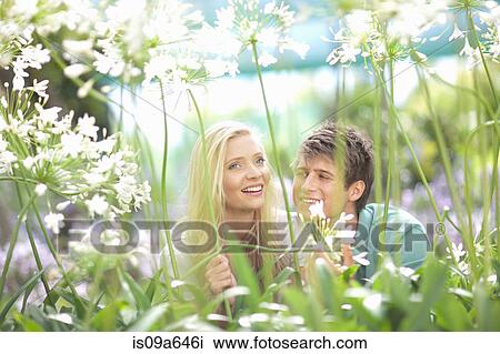 Smiling couple walking in tall plants View Large Photo Image Stock Image - Smiling couple walking in tall plants. Fotosearch