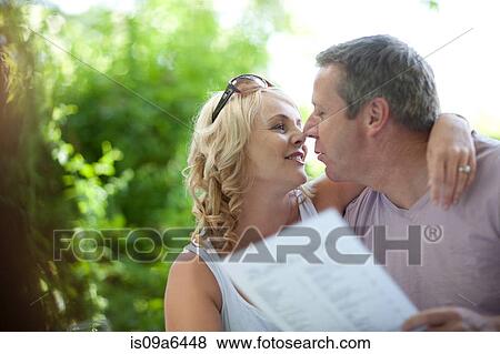 Smiling couple with menu outdoors View Large Photo Image Stock Photo - Smiling couple with menu outdoors. Fotosearch