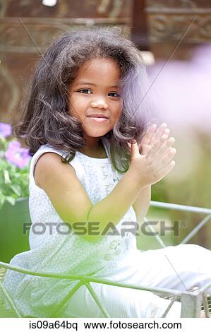 Stock Photography - Smiling girl clapping outdoors. Fotosearch