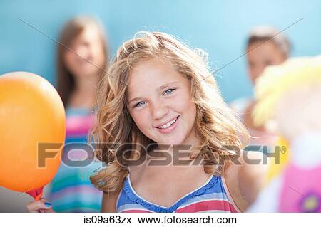 Stock Photo - Smiling girl holding balloon. Fotosearch