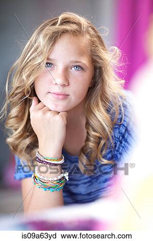 Stock Image - Smiling girl with chin in hand. Fotosearch