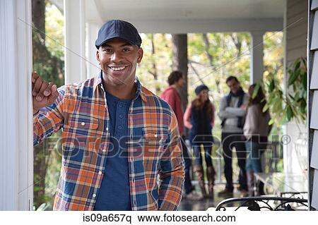 Stock Photography - Smiling man standing on porch. Fotosearch
