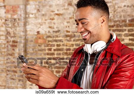 Stock Photograph - Smiling man using cell phone. Fotosearch
