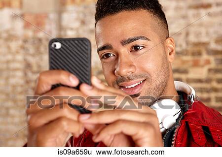 Stock Photograph - Smiling man using cell phone. Fotosearch