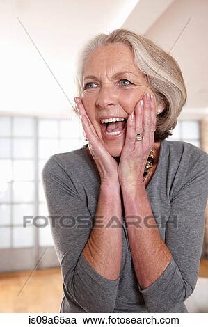Stock Image - Smiling older woman gasping. Fotosearch