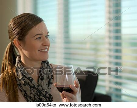 Smiling woman having glass of wine View Large Photo Image Stock Photo - Smiling woman having glass of wine. Fotosearch