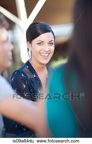 Stock Photograph - Smiling woman sitting at table outdoors. Fotosearch