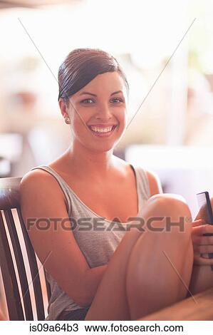 Stock Image - Smiling woman sitting at table. Fotosearch