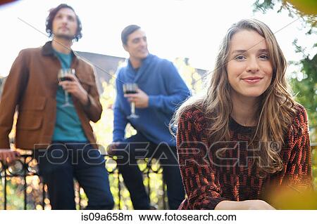 Picture - Smiling woman sitting outdoors. Fotosearch