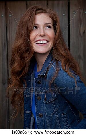 Stock Image - Smiling woman standing outdoors. Fotosearch