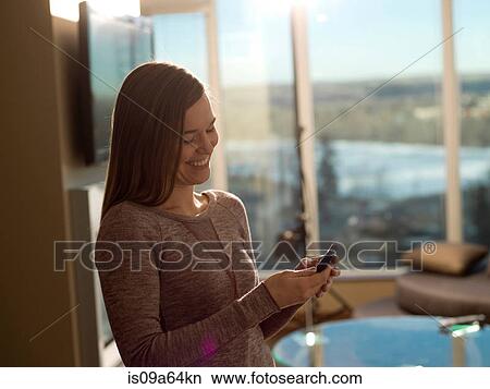 Smiling woman using cell phone View Large Photo Image Picture - Smiling woman using cell phone. Fotosearch