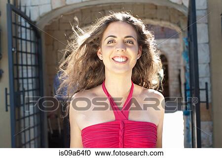 Stock Image - Smiling woman walking outdoors. Fotosearch