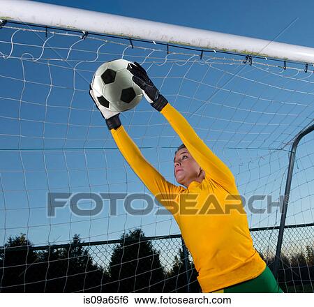 Stock Photograph - Soccer player catching ball in goal. Fotosearch
