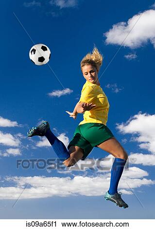 Stock Image - Soccer player kicking in mid-air. Fotosearch
