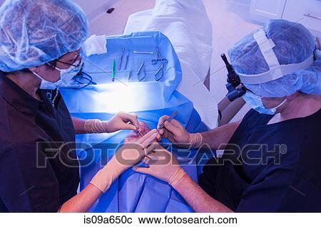Surgeons with patient in operating room View Large Photo Image Stock Image - Surgeons with patient in operating room. Fotosearch