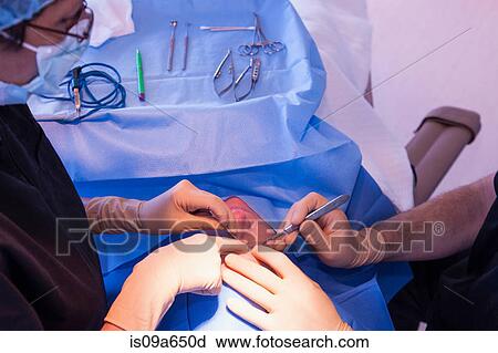 Surgeons with patient in operating room View Large Photo Image Stock Image - Surgeons with patient in operating room. Fotosearch