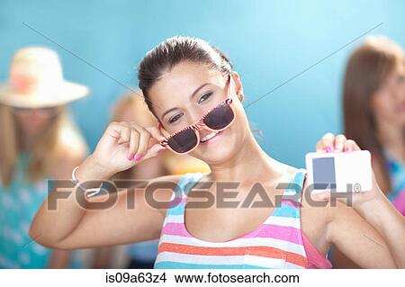 Teenage girl holding mp3 player View Large Photo Image Picture - Teenage girl holding mp3 player. Fotosearch