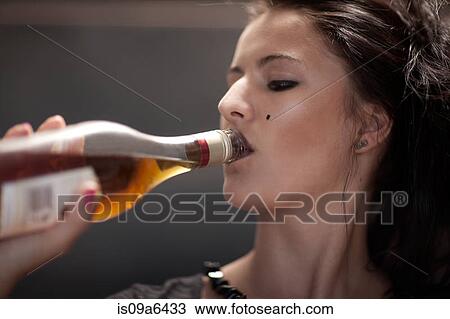 Stock Image - Teenage girl in dark makeup drinking. Fotosearch