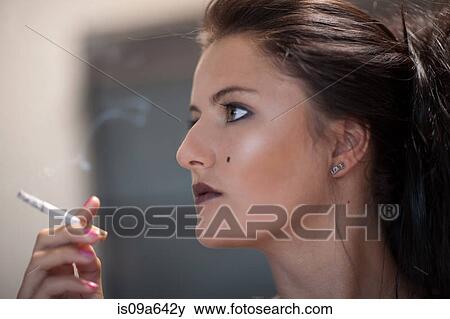 Stock Photo - Teenage girl in dark makeup smoking. Fotosearch