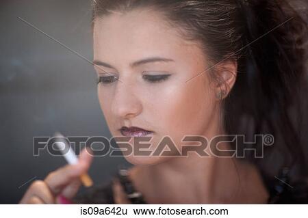 Stock Photograph - Teenage girl in dark makeup smoking. Fotosearch
