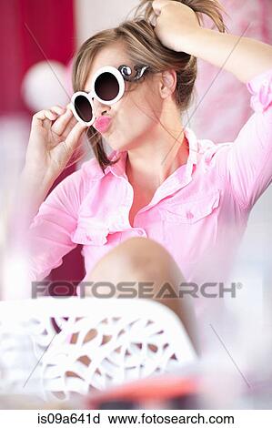 Stock Image - Teenage girl in sunglasses making face. Fotosearch