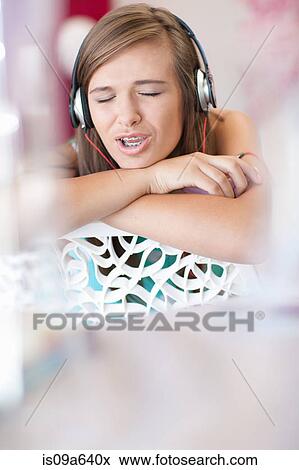 Teenage girl listening to headphones View Large Photo Image Stock Photo - Teenage girl listening to headphones. Fotosearch