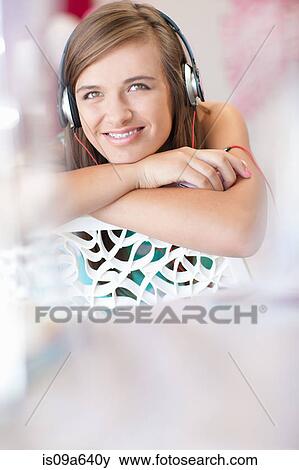 Stock Photo - Teenage girl listening to headphones. Fotosearch
