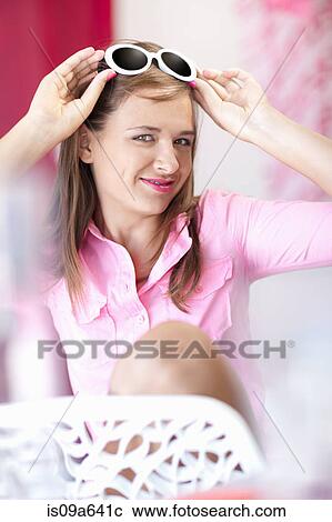 Teenage girl putting on sunglasses View Large Photo Image Stock Image - Teenage girl putting on sunglasses. Fotosearch