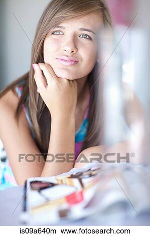Picture - Teenage girl resting chin on hand. Fotosearch