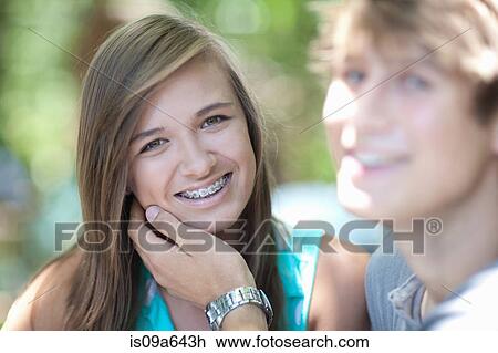 Stock Image - Teenage girl smiling with boyfriend. Fotosearch