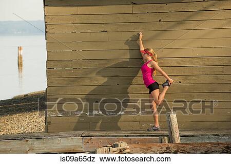 Teenage girl stretching on rocky beach View Large Photo Image Stock Photo - Teenage girl stretching on rocky beach. Fotosearch