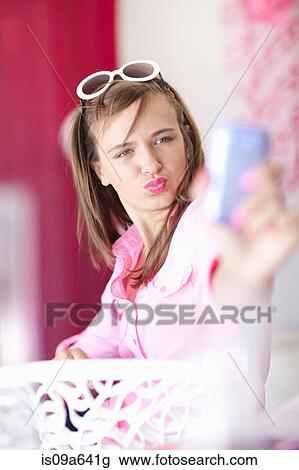 Stock Image - Teenage girl taking picture of herself. Fotosearch