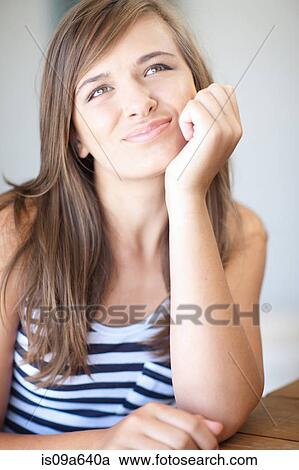 Stock Image - Teenage girl thinking with chin in hand. Fotosearch