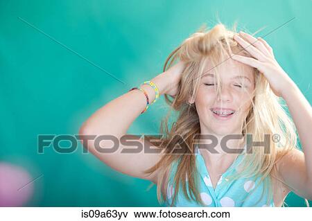 Stock Photo - Teenage girl tossing her hair. Fotosearch
