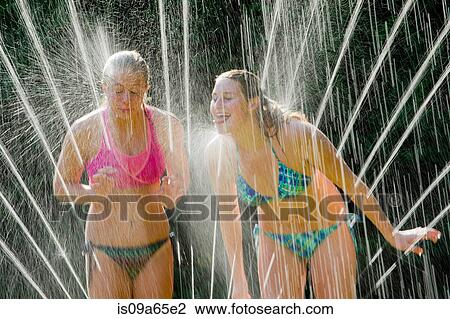 Teenage girls playing in sprinkler View Large Photo Image Stock Image - Teenage girls playing in sprinkler. Fotosearch