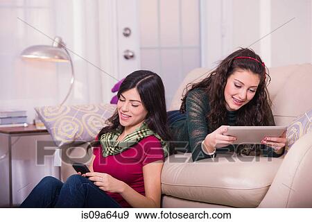 Teenage girls relaxing in living room View Large Photo Image Stock Photo - Teenage girls relaxing in living room. Fotosearch