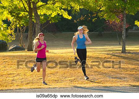 Stock Photography - Teenage girls running together in field. Fotosearch