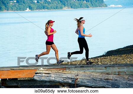 Teenage girls running together on beach View Large Photo Image Stock Photo - Teenage girls running together on beach. Fotosearch