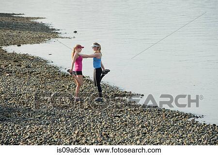 Teenage girls stretching on rocky beach View Large Photo Image Stock Photo - Teenage girls stretching on rocky beach. Fotosearch