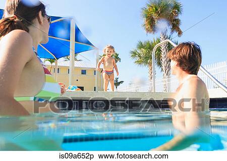 Stock Photography - Toddler running to parents in pool. Fotosearch