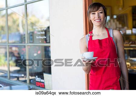 Stock Photo - Waitress holding cup of coffee in cafe. Fotosearch
